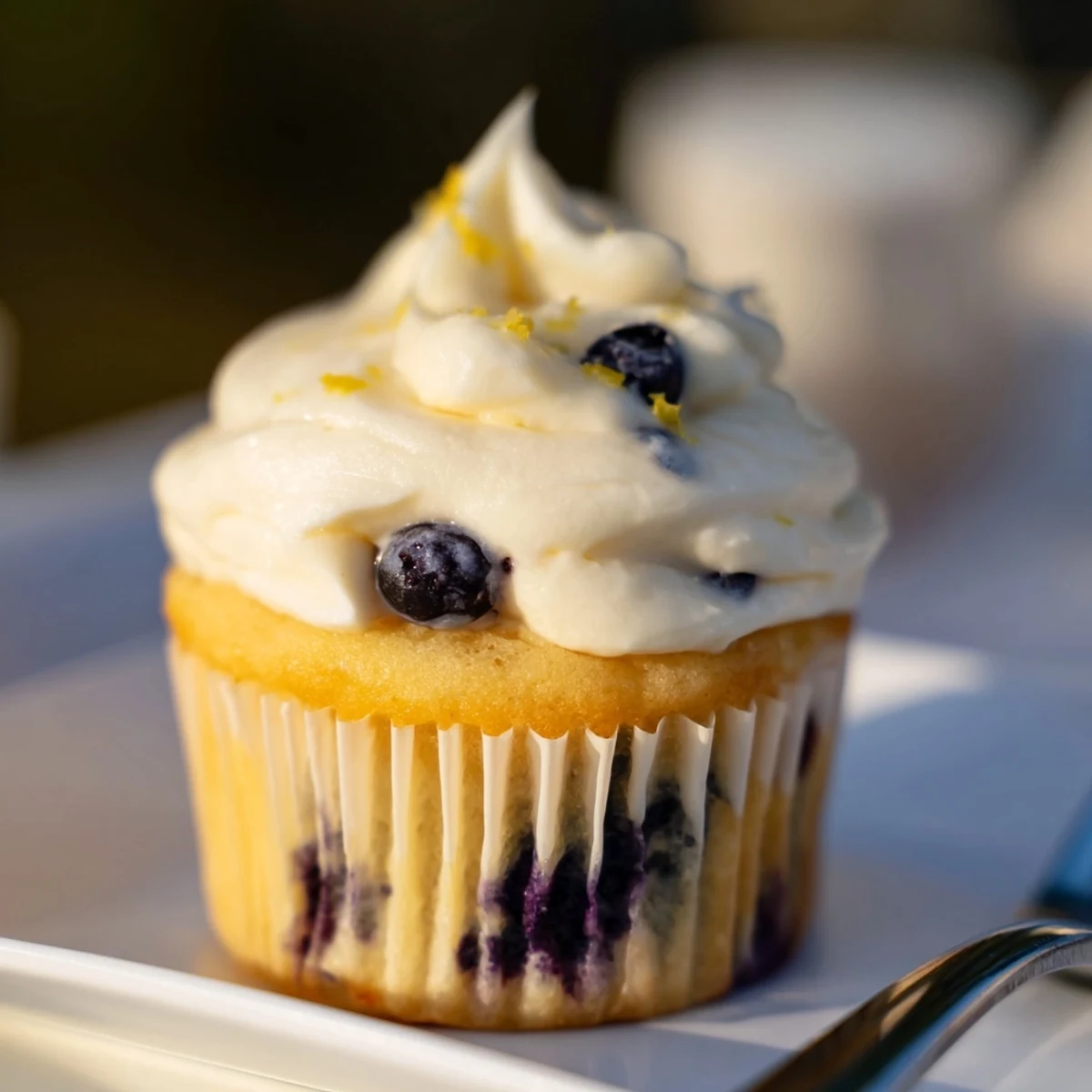 Fluffy lemon blueberry cupcakes with zesty citrus flavor and tangy cream cheese frosting on top