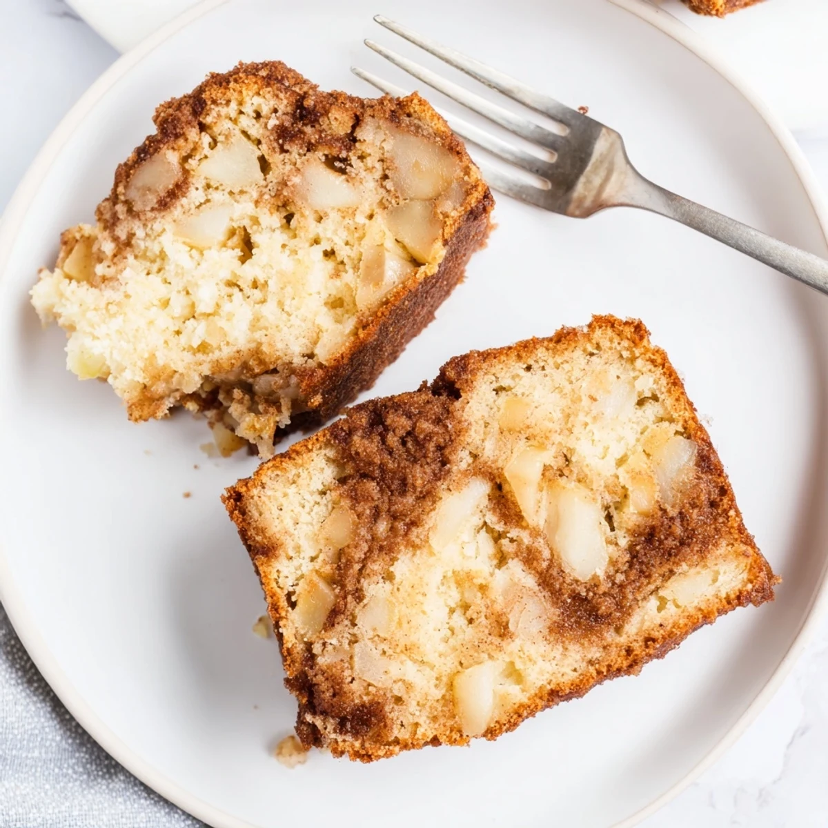 Golden cinnamon apple bread loaf with marbled sugar swirl and tender diced apple chunks