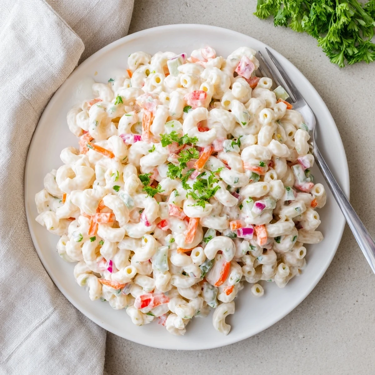 Colorful bowl of Tangy And Creamy Macaroni Salad with red bell peppers and celery
