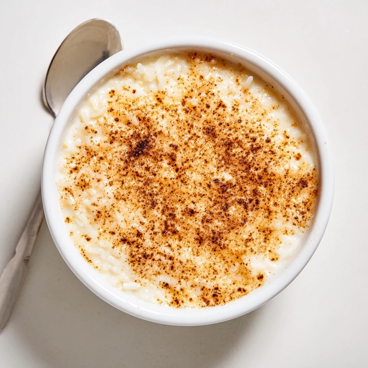 Silky Portuguese rice custard speckled with warm cinnamon, served in small dishes