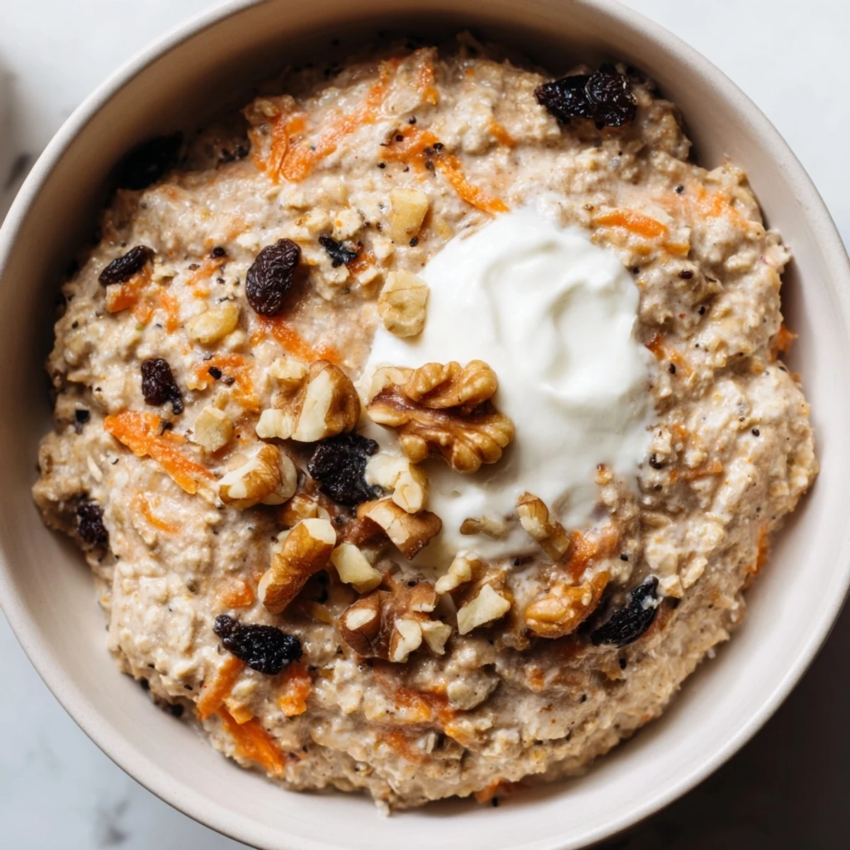 Creamy carrot cake overnight oats in a mason jar topped with crunchy walnuts and cinnamon