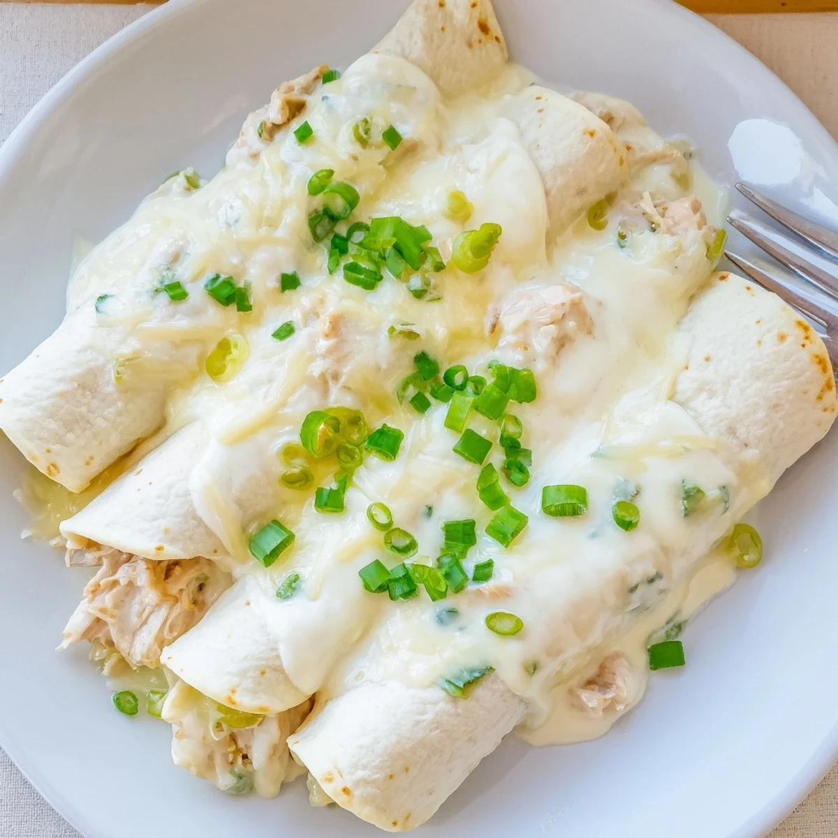 Baked Creamy White Chicken Enchiladas in 9x13 dish, ready for family dinner