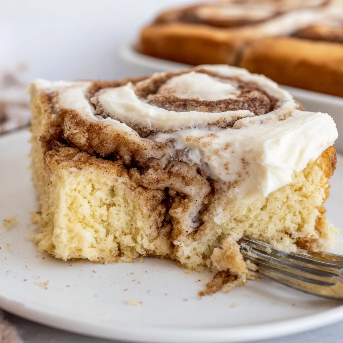 Warm Cinnamon Roll Poke Cake sliced on platter, aroma of brown sugar