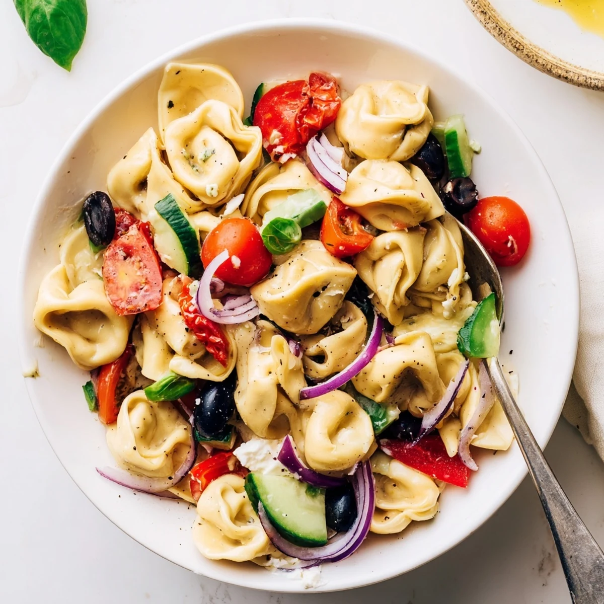 Tortellini Pasta Salad with sun-dried tomatoes and basil, chilled for picnics