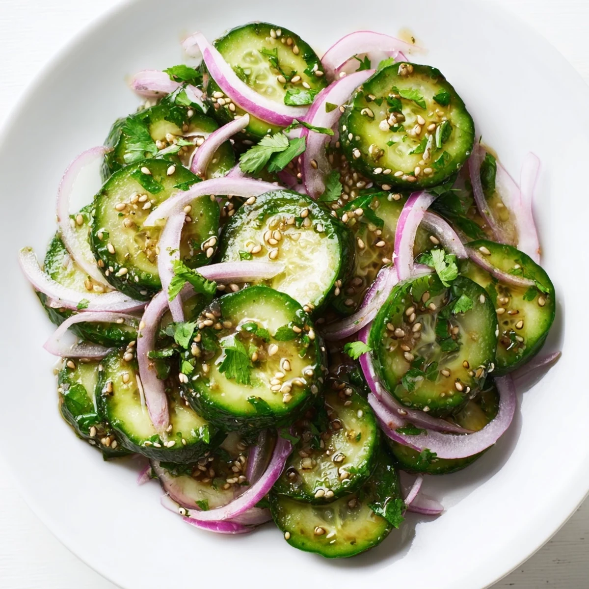 Colorful bowl of honey lime cucumber salad drizzled with sweet and tangy lime honey dressing garnished with fresh herbs.