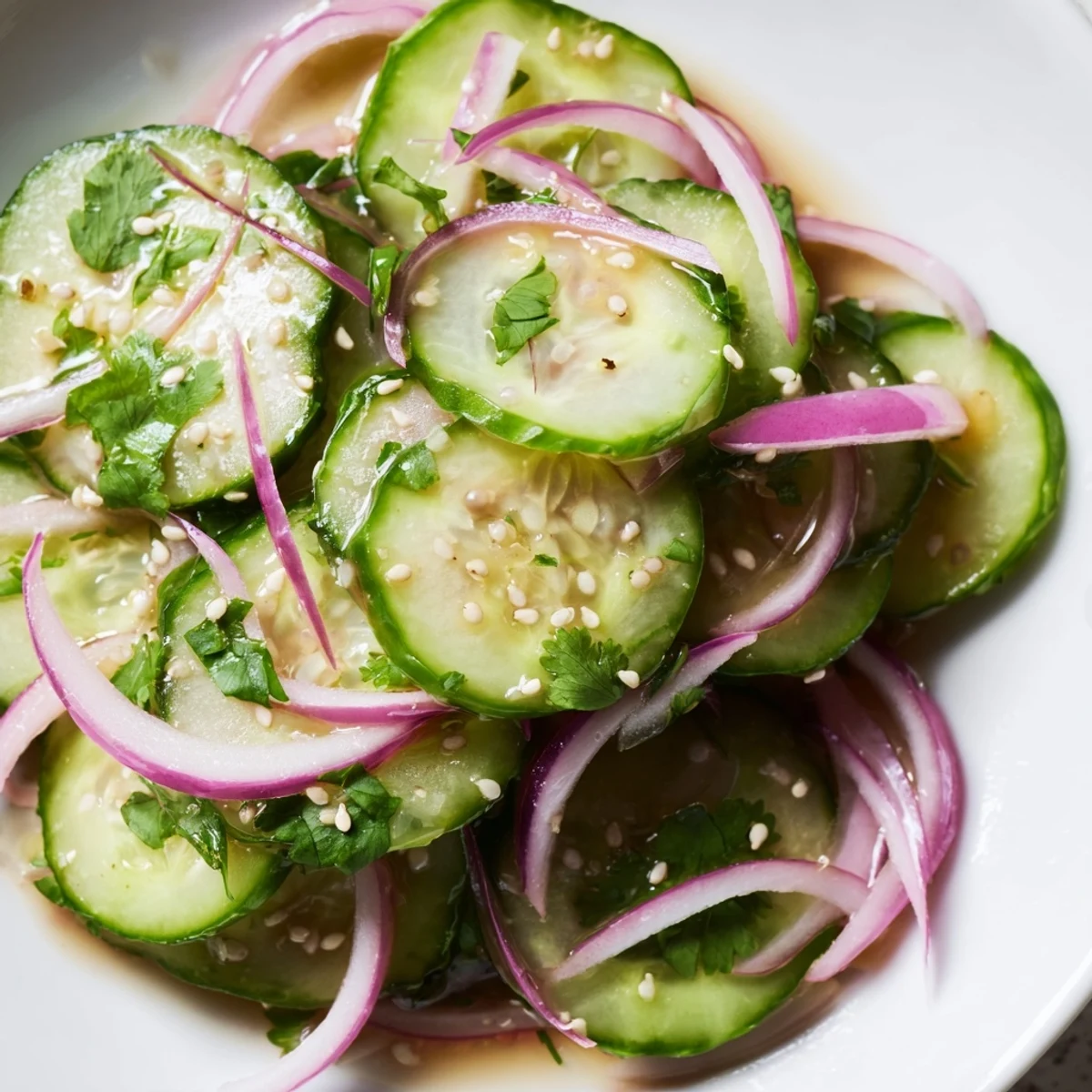 Light and refreshing honey lime cucumber salad with thinly sliced cucumbers coated in glossy honey lime dressing and sesame seeds.