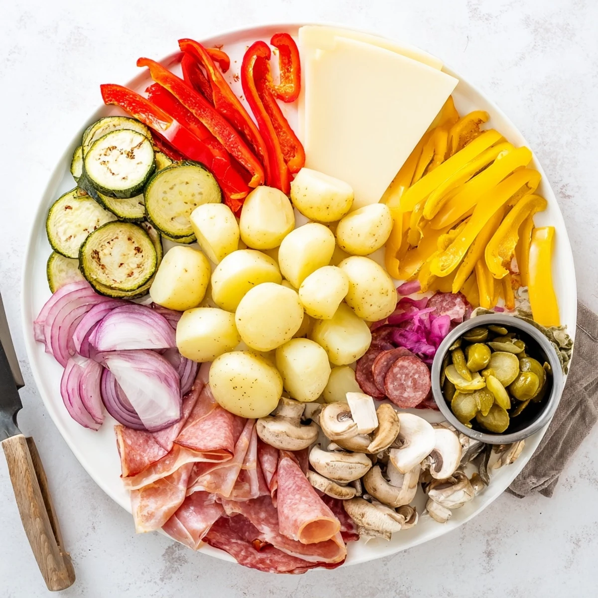 Bubbling Swiss raclette cheese melts under the grill served with pickled onions and charcuterie for an interactive dinner