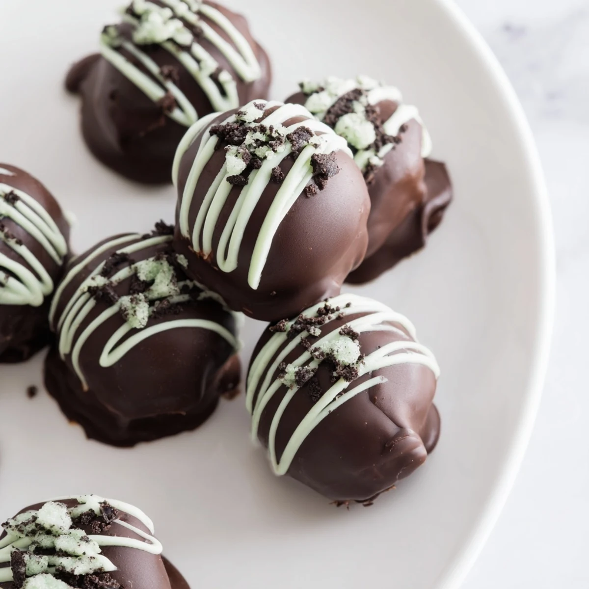 Dark chocolate dipped mint Oreo truffles arranged on a serving platter for parties