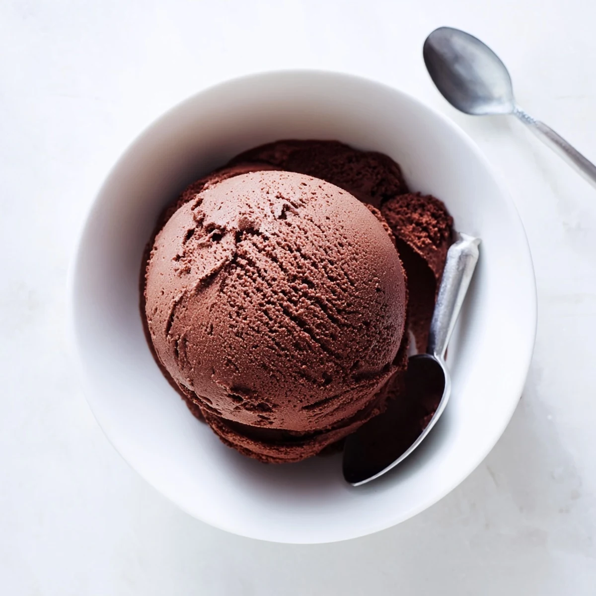 Homemade chocolate sourdough ice cream melting slightly in a chilled serving bowl