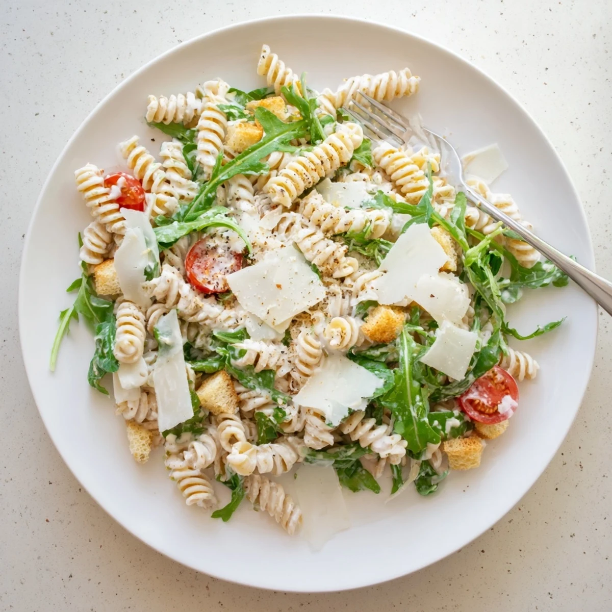 Bright Arugula Pasta Caesar Salad tossed in creamy lemon-Dijon dressing, ready  
