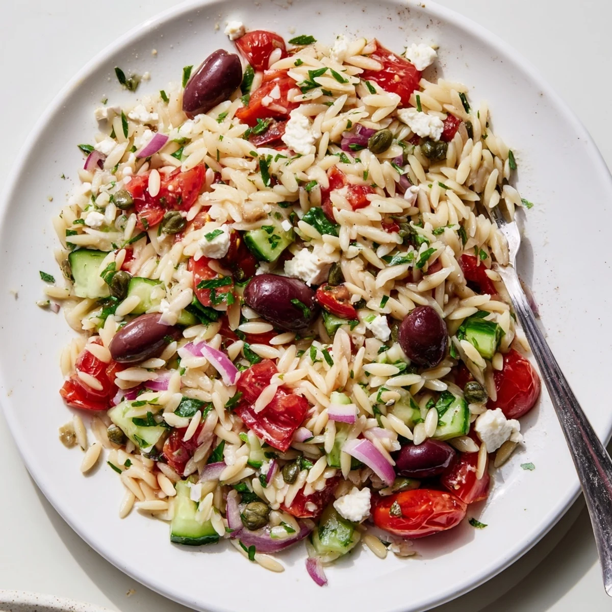 Bright Mediterranean orzo pasta salad in a rustic bowl with colorful vegetables and crumbled feta