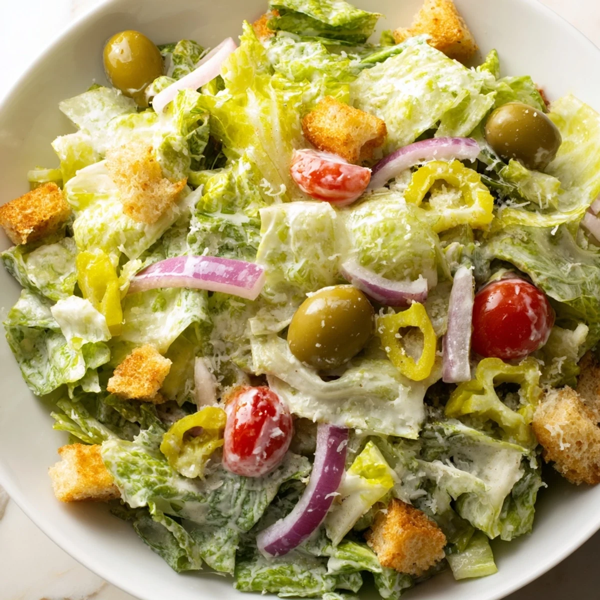 Crisp Olive Garden Salad topped with juicy tomatoes, pepperoncini, and creamy dressing