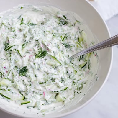 Bowl of healthy radish tzatziki dip served with crisp vegetable crudités for appetizers