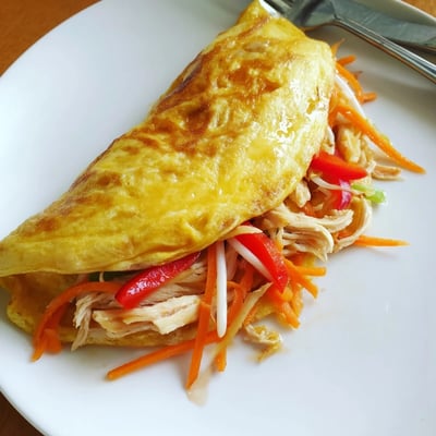 Fluffy Chinese omelette folded over crisp carrots, bean sprouts, and bell peppers